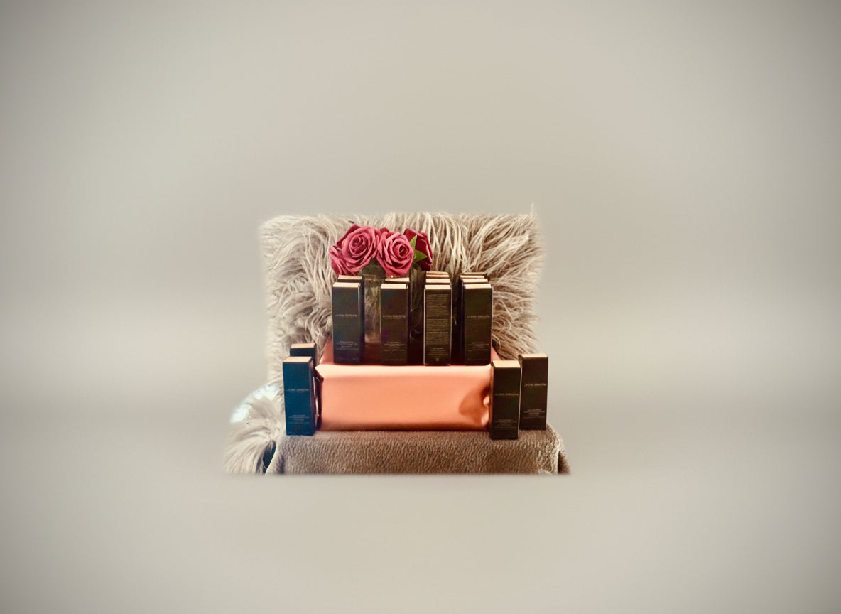 Various colors of new Laura Mercia foundation displayed on a stand with decorative elements.